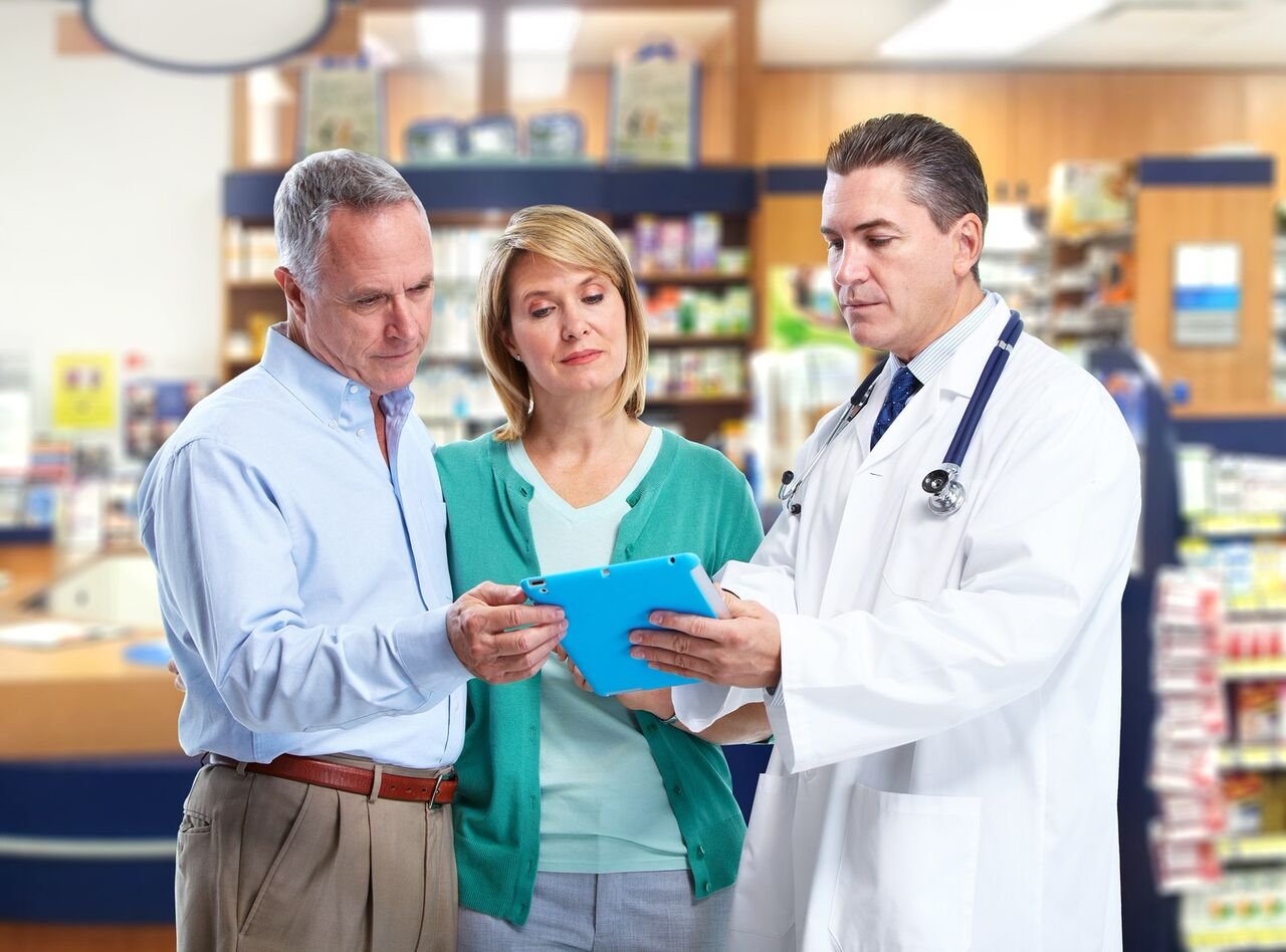 Pharmacist consulting with man and woman